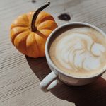pumpkin spice latte next to a little mini pumpkin